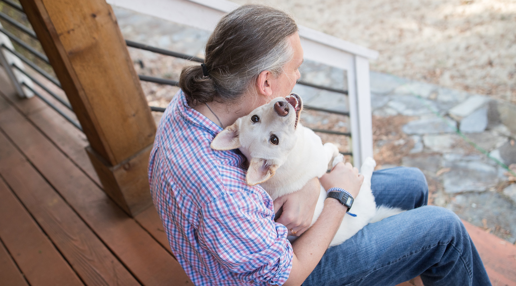 Belle sits in Rick's lap looking up at the camera