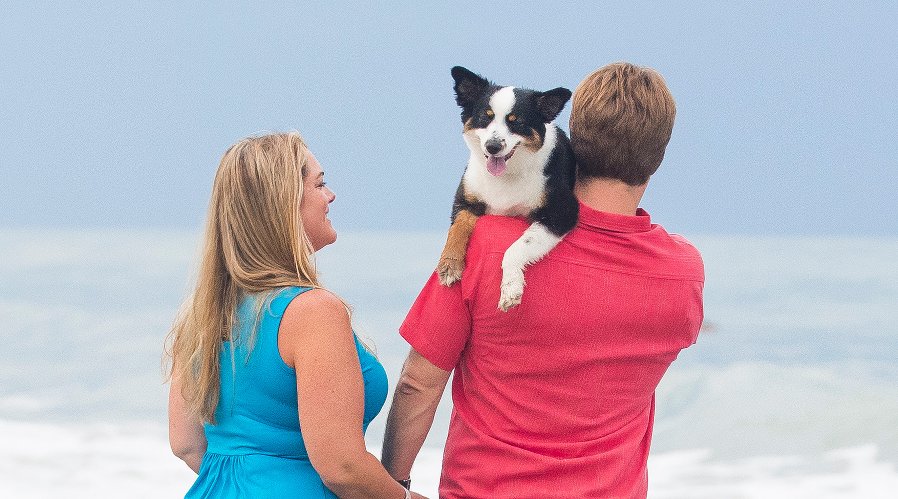 Kelly, Marc and Dublin walking away from the camera toward the ocean