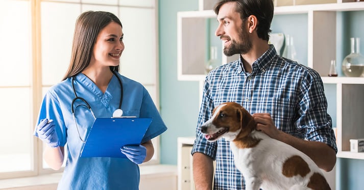 Pet parent at the veterinarian with dog